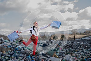 Modern woman on landfill, consumerism versus pollution concept. photo