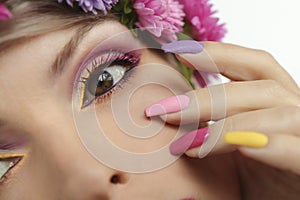 Fashionable multi-colored makeup and manicure on long nails