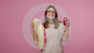 Fashionable optimistic brunette woman with eyeglasses holding rubber ring and drinking cocktail, dancing