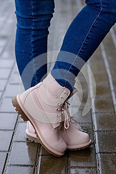 Fashionable pink boots on woman`s legs