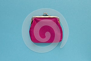 Fashionable pink wallet on a blue background. Close up