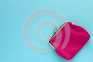 Fashionable pink wallet on a blue background. Close up