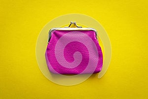 Fashionable pink wallet on a yellow background. Close up