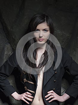 Fashionable portrait of a brunette girl over rock background.