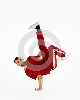 Fashionable portrait. Stylishly dressed man performing freestyle, breakdance, standing on hands and legs raised up