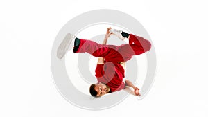 Fashionable portrait. Stylishly dressed young man dancing in freestyle, breakdance style in motion against white