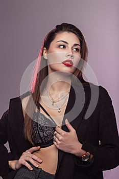 Fashionable portrait young woman with brown hair with healthy clean skin with beautiful puffy red lips in stylish black jacket in