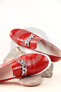 Fashionable red shoes, moccasins, shoes on trendy stone podium. Vertical photo. Fashion, style, stylist. Place for text