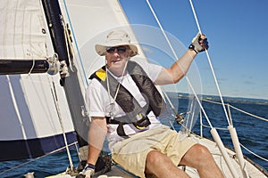 Fashionable senior fisherman in a hat and breeches looking at the camera.A senior citizen is wearing a life jacket.