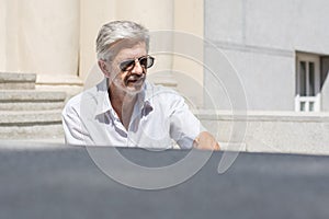 Fashionable senior man sitting on stairs photo