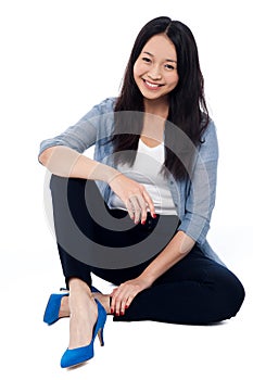 Fashionable smiling girl sitting on the floor