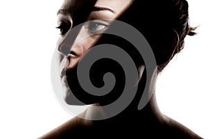 Fashionable studio portrait of a cute girl. Silhouette of a beautiful young woman with hard shadows on her face against white
