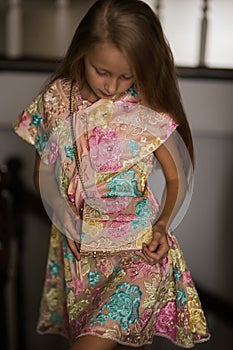 Fashionable style of clothes for children. Little little girl wearing a beautiful lace dress with a handbag. Girl model with long