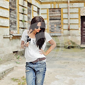 Fashionable stylish girl with old camera wearing sunglasses and