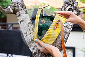 Fashionable stylish rattan bag outside. Tropical island of Bali, Indonesia. Rattan handbag.