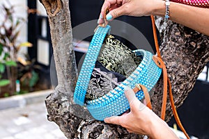 Fashionable stylish rattan bag outside. Tropical island of Bali, Indonesia. Rattan handbag.