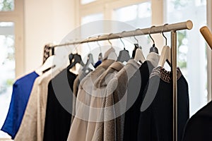 Fashionable stylish women`s clothing on a hanger. Branded clothing in a show room. Light background. Fashion retail, show room