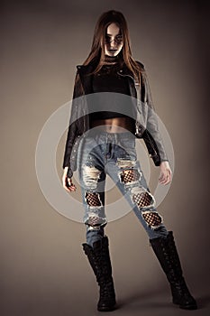 Fashionable teenager girl in leather jacket and torn jeans