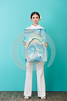 fashionable teenager holding abstract oil painting