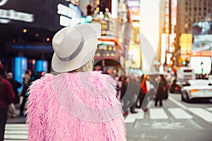 Fashionable tourist woman visiting New York City Time`s Square wearing stylish street style outfit