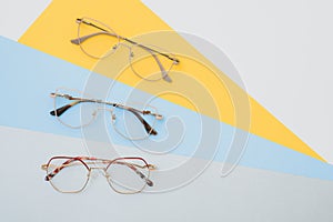 Fashionable trendy eyes glasses for correction of vision on a colorful background, geometric background from paper of pastel