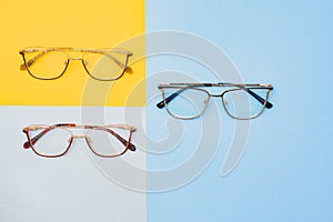 Fashionable trendy eyes glasses for correction of vision on a colorful background, geometric background from paper of pastel