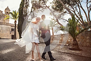 Fashionable wedding couple near Catholic church. Bride and Groom. Outdoor portrait