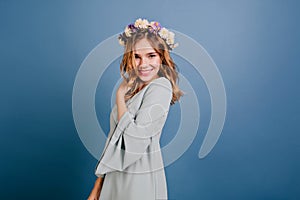 Fashionable white girl in light-blue outfit having fun in studio. Indoor portrait of laughing curly woman isolated on