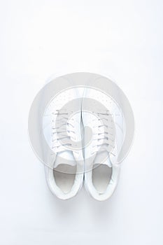 Fashionable white sneakers on white background, minimalism, top view, creative layout.