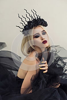 Fashionable woman in black open dress and floral crown