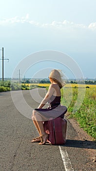 Fashionable woman hitchhiking at roadside