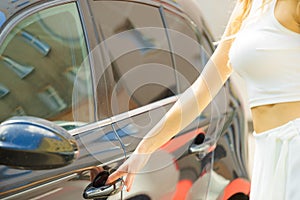 Fashionable woman opening car