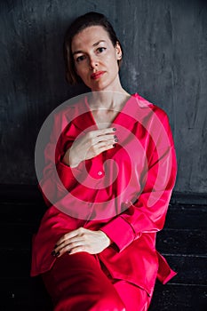 Fashionable woman in pajamas in black room