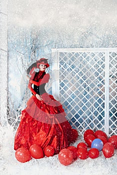 Fashionable woman in red lavish dress posing.