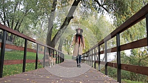 Fashionable woman walking the dog in public park