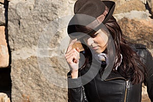 Fashionable woman wearing hat and leather jacket