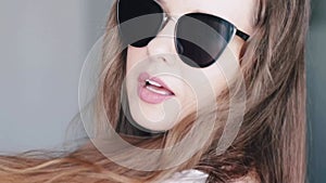 Fashionable woman wearing stylish sunglasses and smiling, beauty face portrait of a caucasian european model as fashion