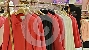 Fashionable women dress on hangers in clothing shop