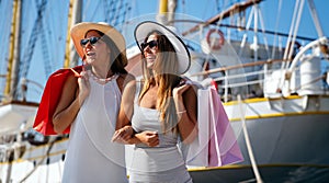 Fashionable women out on the street with shopping bags enjoying summer vacation and travel.