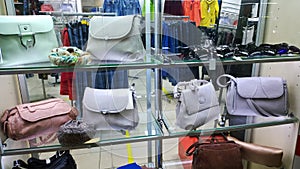 Fashionable women`s handbags in pastel color on shop window. Clothing and accessories Fashion Boutique. Glass showcase. New