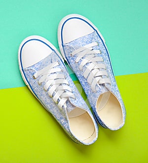 Fashionable women & x27;s sneakers with white laces from the 80s on a green blue paper background.