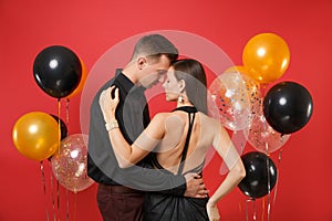 Fashionable young couple in black clothes celebrating birthday holiday party on bright red background air
