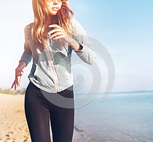 Fashionable young longhaired woman have morning jogging on the calm sea coast