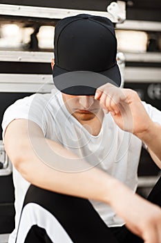 Fashionable young man with a black cap covers the face