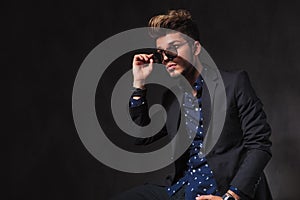 Fashionable young man posing in dark studio background while sea