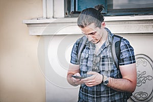 Fashionable young man using a phone outdoors