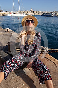 Fashionable young traveler woman sitting at Mediterranean sea