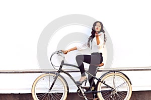 Fashionable young woman on bicycle giving air kiss