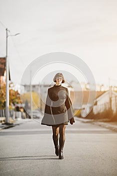 Fashionable young woman in black dress walks down the street, fashion and clothing concept