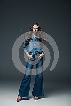 fashionable young woman girl with long hair posing in flare jeans